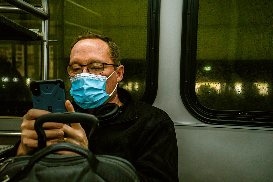 Man Wearing Face Mask Using Smartphone on Subway