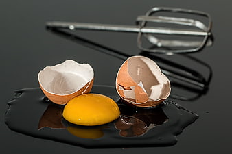 Broken Raw Egg Yolk and Shell on Black Surface