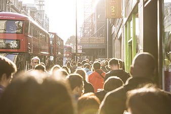 Crowded London street with red double-decker buses and shoppers
