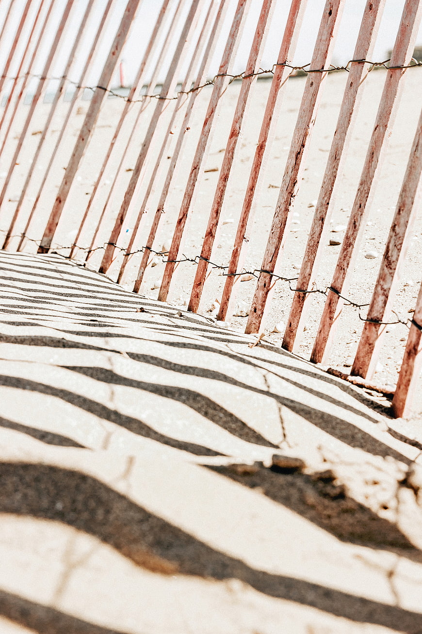 Wooden Beach Fence with Barbed Wire and Sand Shadows