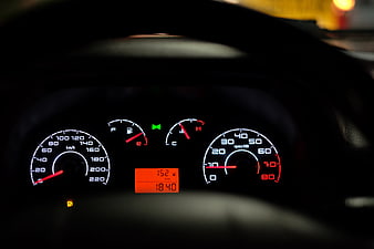 Car Dashboard Instrument Cluster at Night with Speedometer and Tachometer