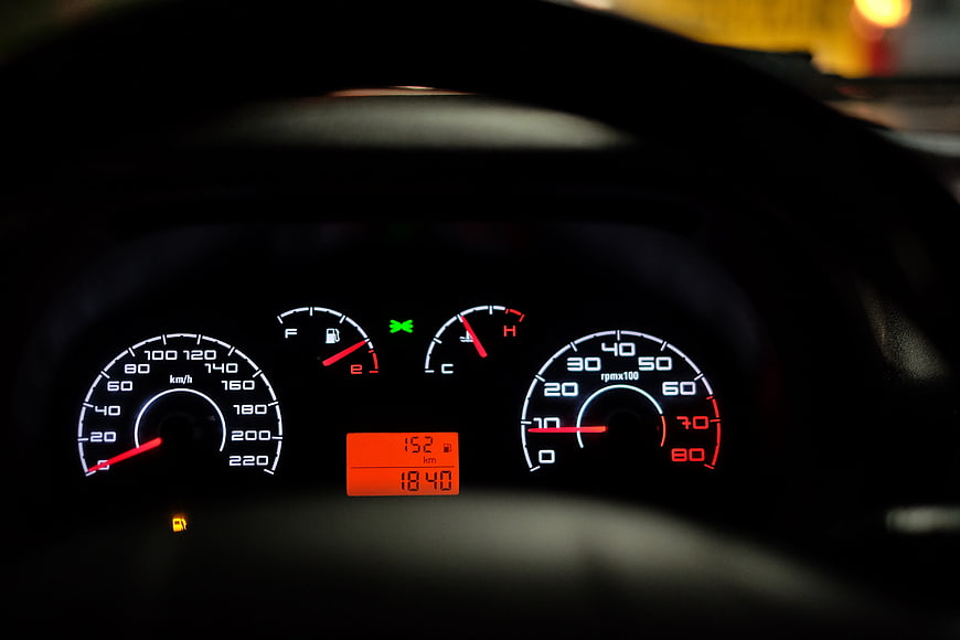 Car Dashboard Instrument Cluster at Night with Speedometer and Tachometer