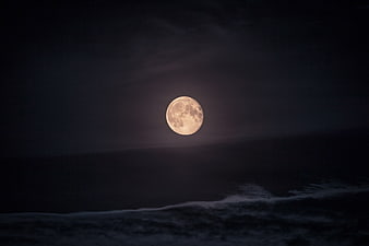 Full Moon Rising Over Dark Ocean Waves at Night