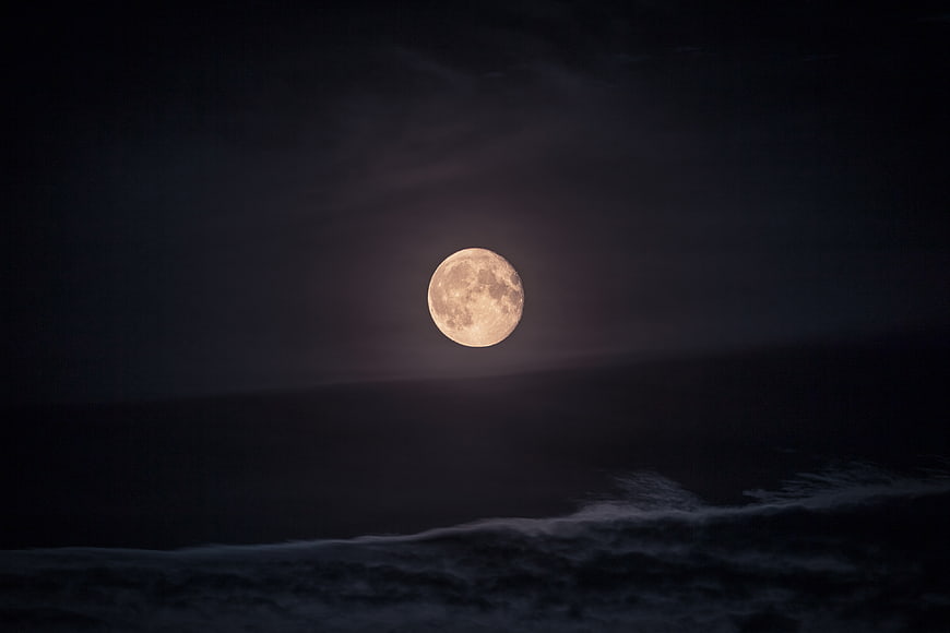 Full Moon Rising Over Dark Ocean Waves at Night