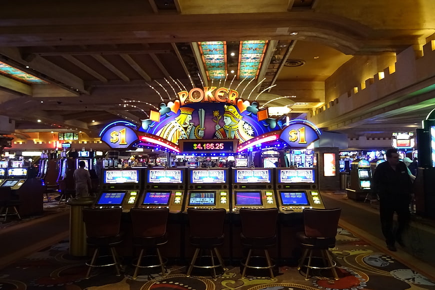 Casino Poker Machine Row With Neon Signage And Chairs