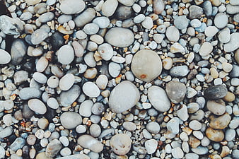 Close-up texture of smooth multicolored pebbles on a beach