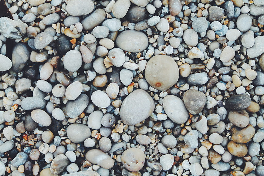 Close-up texture of smooth multicolored pebbles on a beach