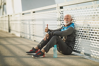 Happy Senior Man Resting After Outdoor Run on Bridge