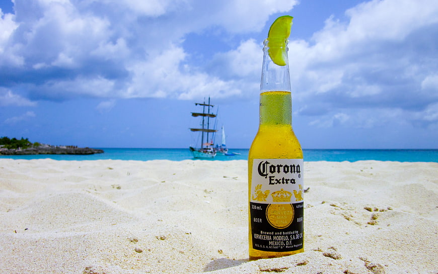 Corona Extra beer bottle with lime on tropical beach