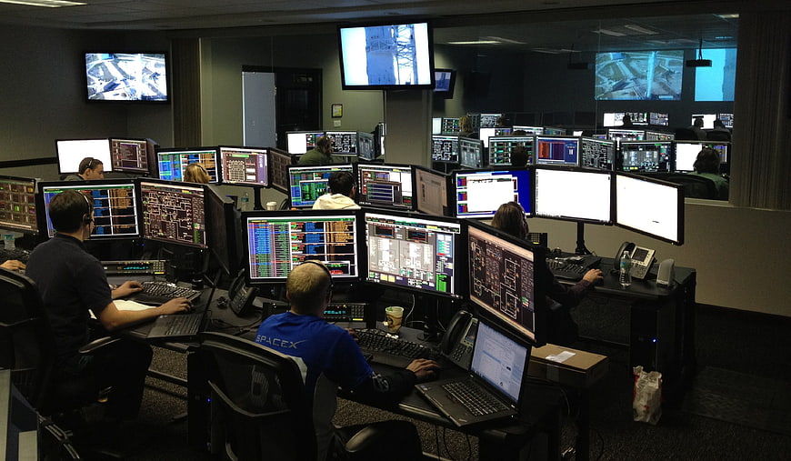 Mission Control Room with Engineers Monitoring Screens