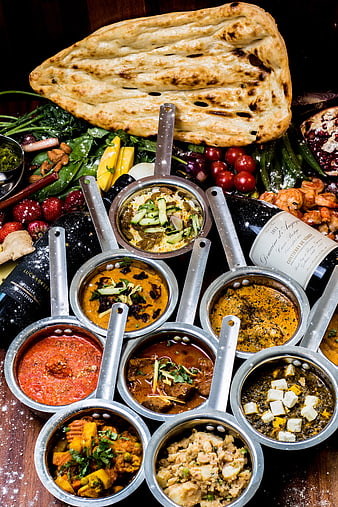 Overhead view of assorted Indian curries and naan bread spread