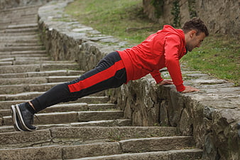 Man doing push-ups on stone steps outdoors
