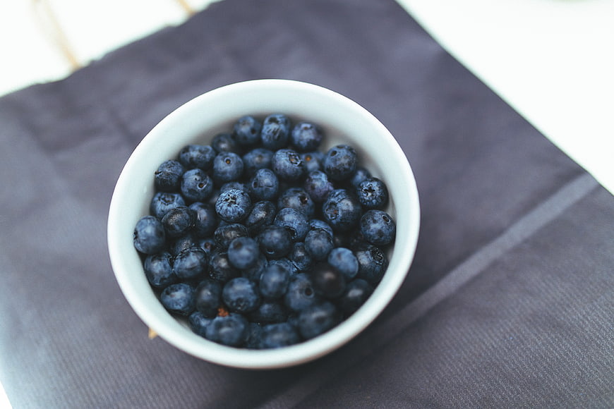 Top View of Fresh Blueberries in White Bowl on Dark Cloth