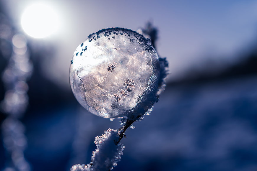 Frozen Soap Bubble with Ice Crystals in Winter Sunlight