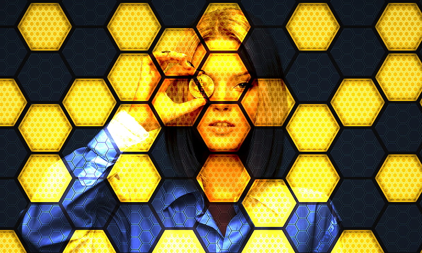 Woman with magnifying glass over yellow hexagon honeycomb pattern