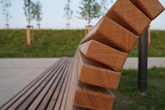 Close-up of wooden park bench slats with blurred green background