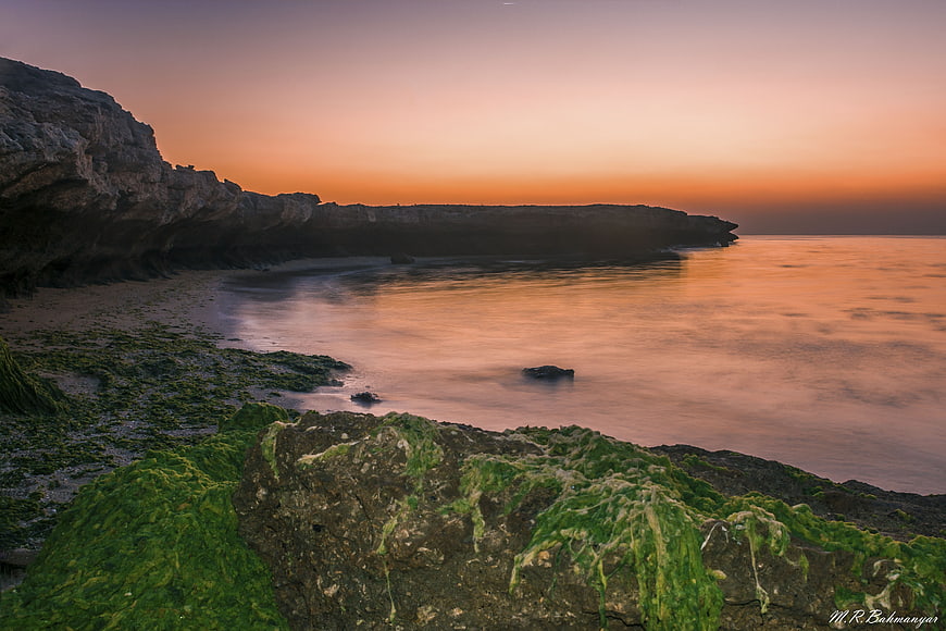 Serene Sunset at Nayband Gulf with Mossy Rocks