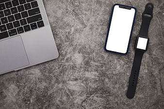 Top view of laptop, smartphone, and smartwatch on concrete background
