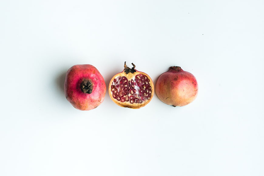 Fresh pomegranates on white background top view