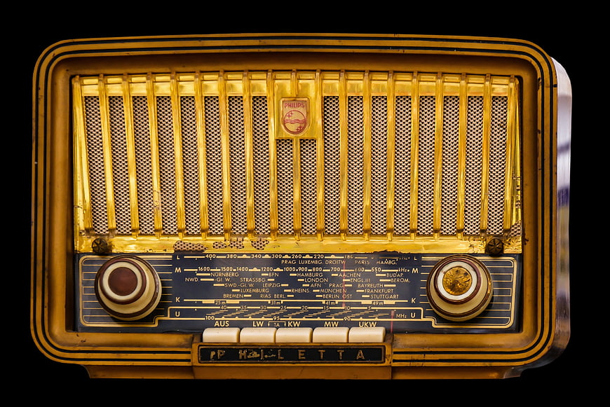 Vintage yellow Philips Halletta tube radio isolated on black