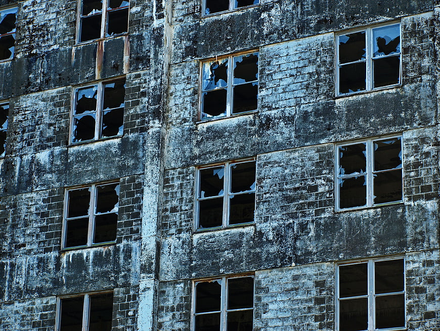Weathered Brick Building Facade with Broken Windows