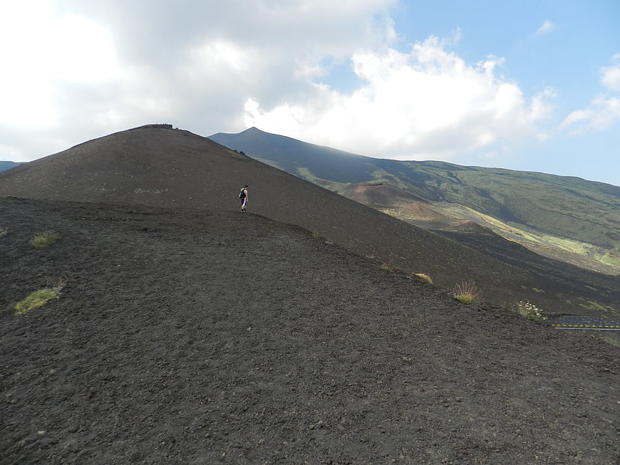 Hiker walking on volcanic slopes of Mount Etna, Sicily