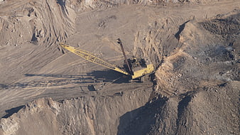 Aerial view of yellow dragline excavator in open pit mine