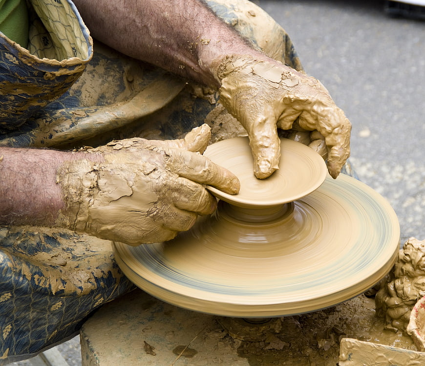 Close-up of potter's hands shaping clay on a spinning wheel