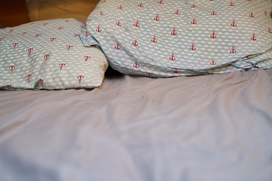 Nautical Anchor Patterned Pillows On White Bedding
