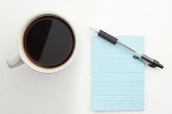 Top View Coffee Cup and Blue Notepad on White Desk