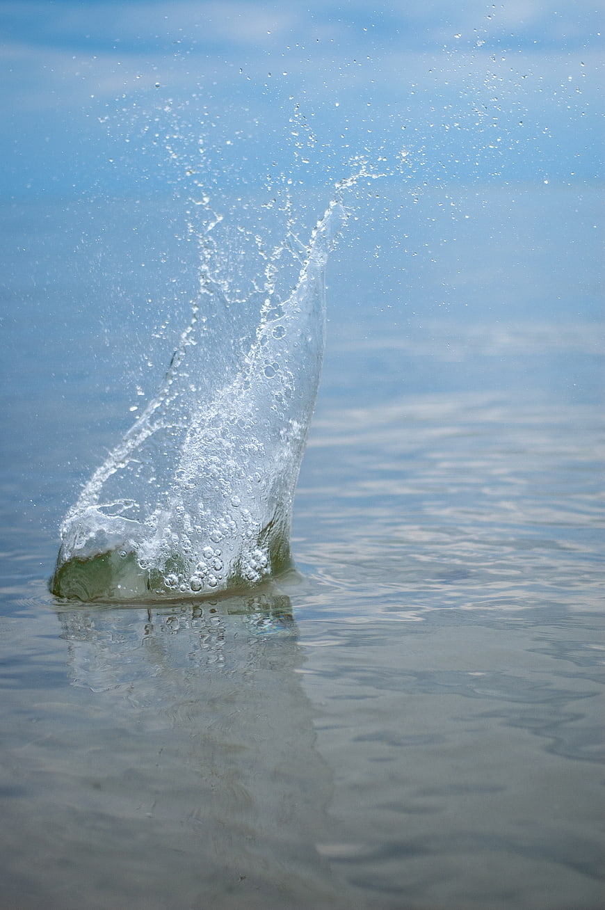 Dynamic Water Splash Rising from Calm Blue Lake Surface