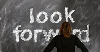 Woman looking at chalkboard with look forward written