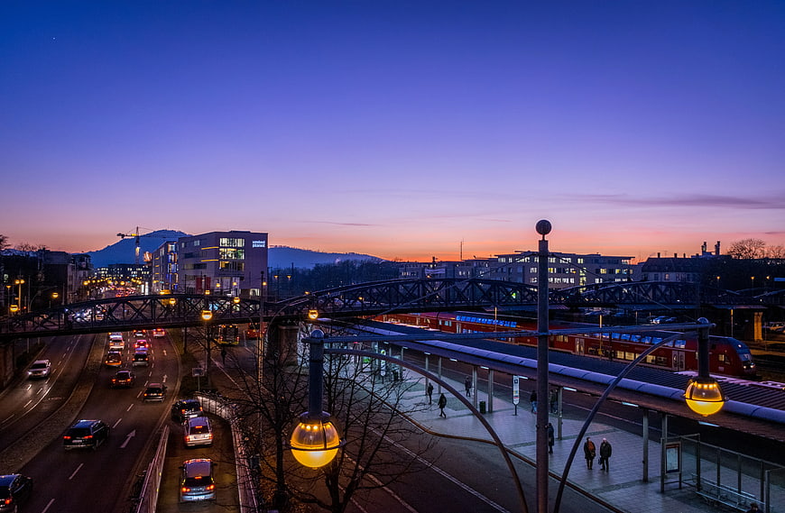 Cityscape at Dusk with Train Station and Highway Traffic