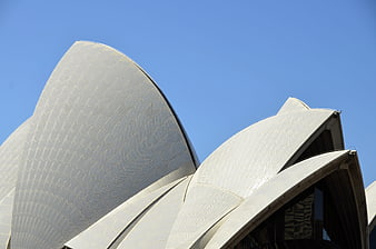 Close-up of Sydney Opera House white tiled roof against blue sky