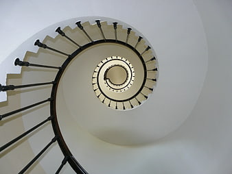 Top-down view of a white spiral staircase with black railing