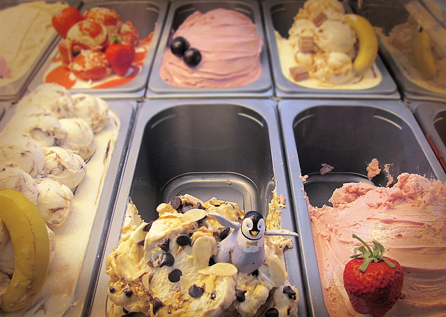 Ice cream display case with penguin figurine and fruit toppings