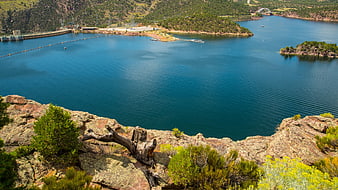 Scenic View of Blue Reservoir with Dam and Rocky Foreground