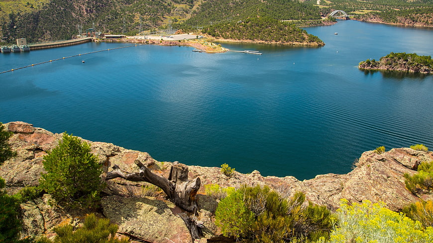Scenic View of Blue Reservoir with Dam and Rocky Foreground