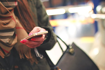 Close-up of Woman Holding Smartphone with Pink Nails