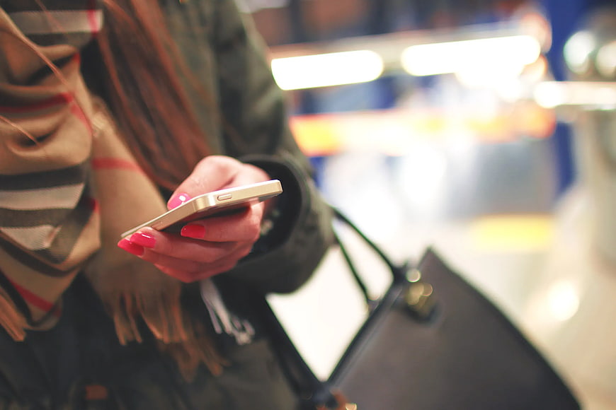 Close-up of Woman Holding Smartphone with Pink Nails