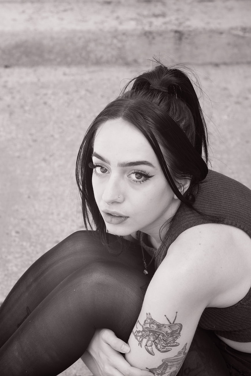 Black and white portrait of young woman with tattoo