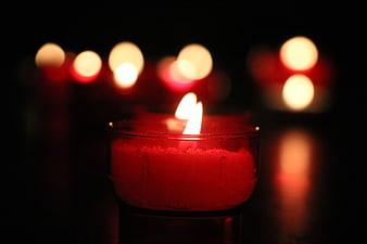 Red Candle Flame In Dark Setting With Bokeh Background