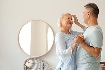 Happy Senior Couple Dancing Together in Bright Living Room