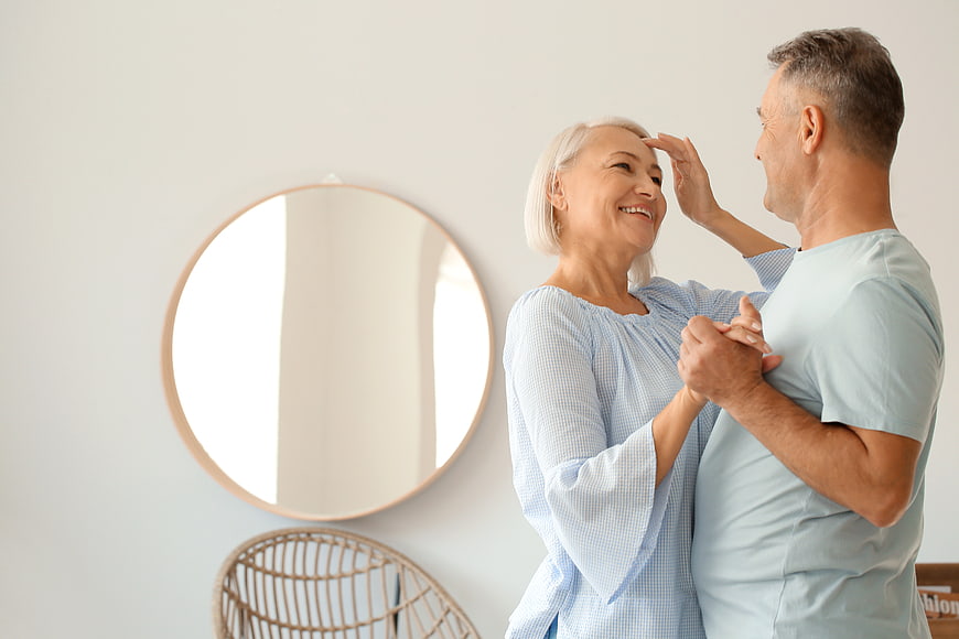 Happy Senior Couple Dancing Together in Bright Living Room