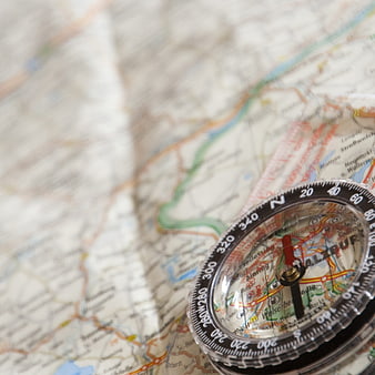 Close-up of compass on map for travel navigation