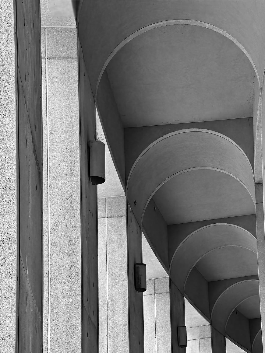 Black and white architectural detail of concrete arches and pillars