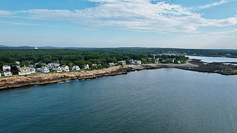 Aerial View of Coastal Town with Rocky Shoreline and Blue Ocean