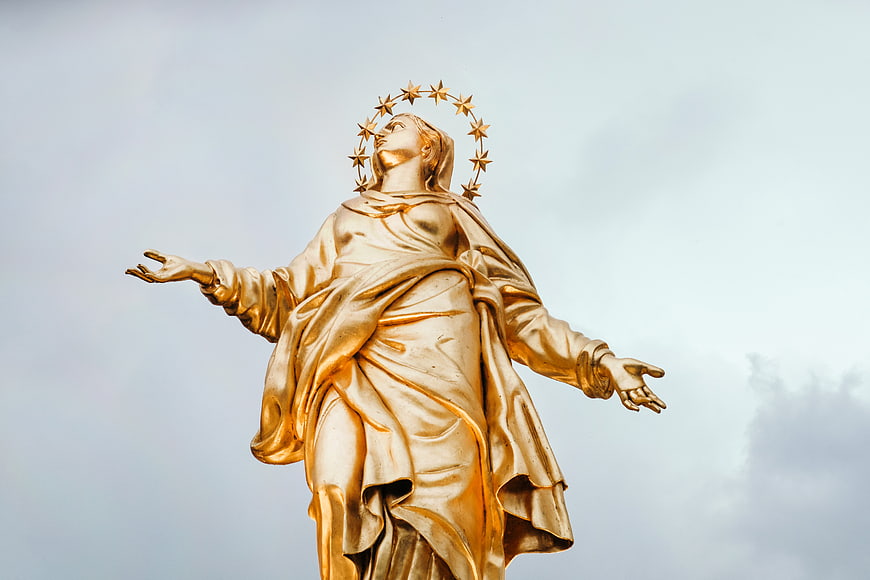 Golden Madonna Statue with Star Crown Against Sky