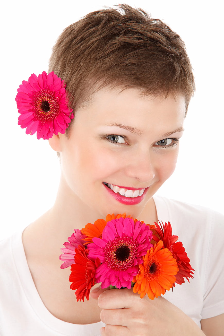 Smiling Woman with Short Hair Holding Gerbera Flowers