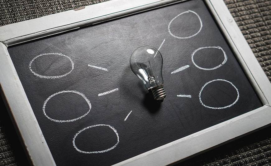Light bulb on chalkboard with brainstorming circles diagram